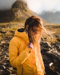 Portrait of young woman in yellow jacket in nature