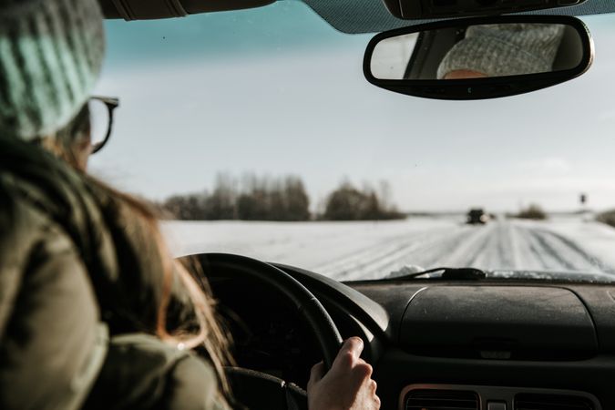 Woman driving car on snow field