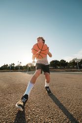 Active boy throwing ball in hoop during training