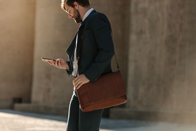 Man using mobile phone while commuting to office