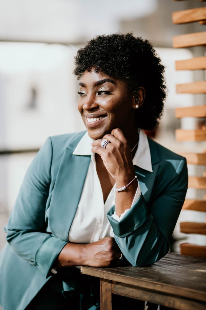 Smiling woman in teal blazer looking away