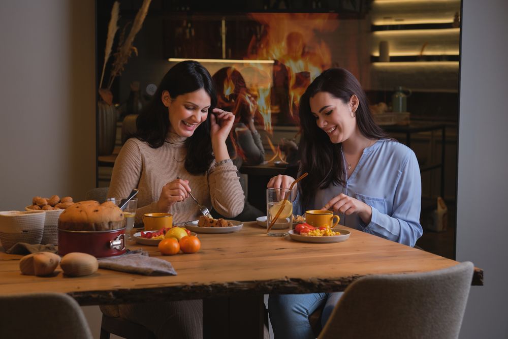 Happy women laughing and cake at home