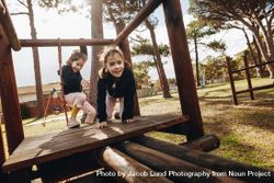 Two little girls playing at playground outdoors 5z8xQb