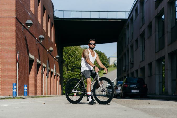 Man riding bike next to buildings