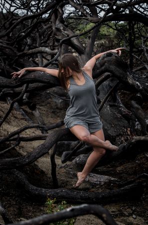 Woman posing on twigs of dry trees