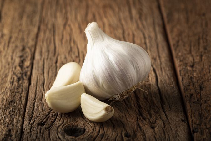 Garlic bulb and garlic cloves on the wooden table.
