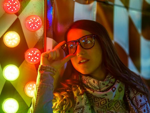 Stylish young woman near illuminated board