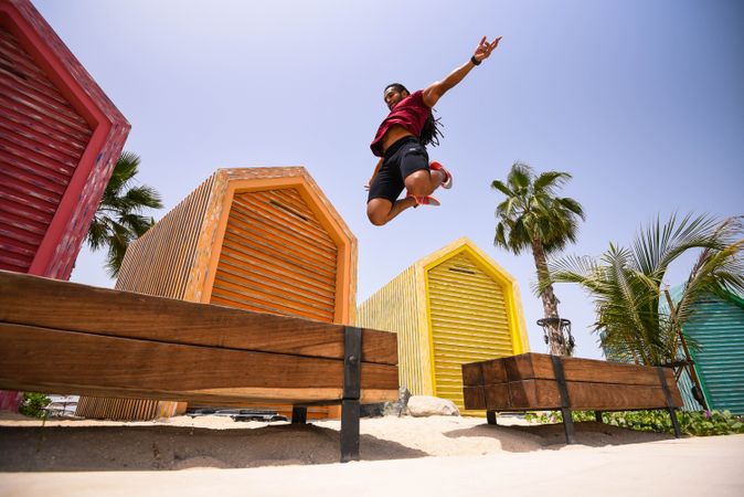 Man jumping beside colorful shacks