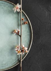 Top view of spring table setting with blooming tree branch on ceramic plate