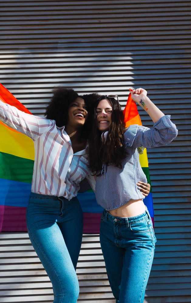 Women standing with LGBT flag