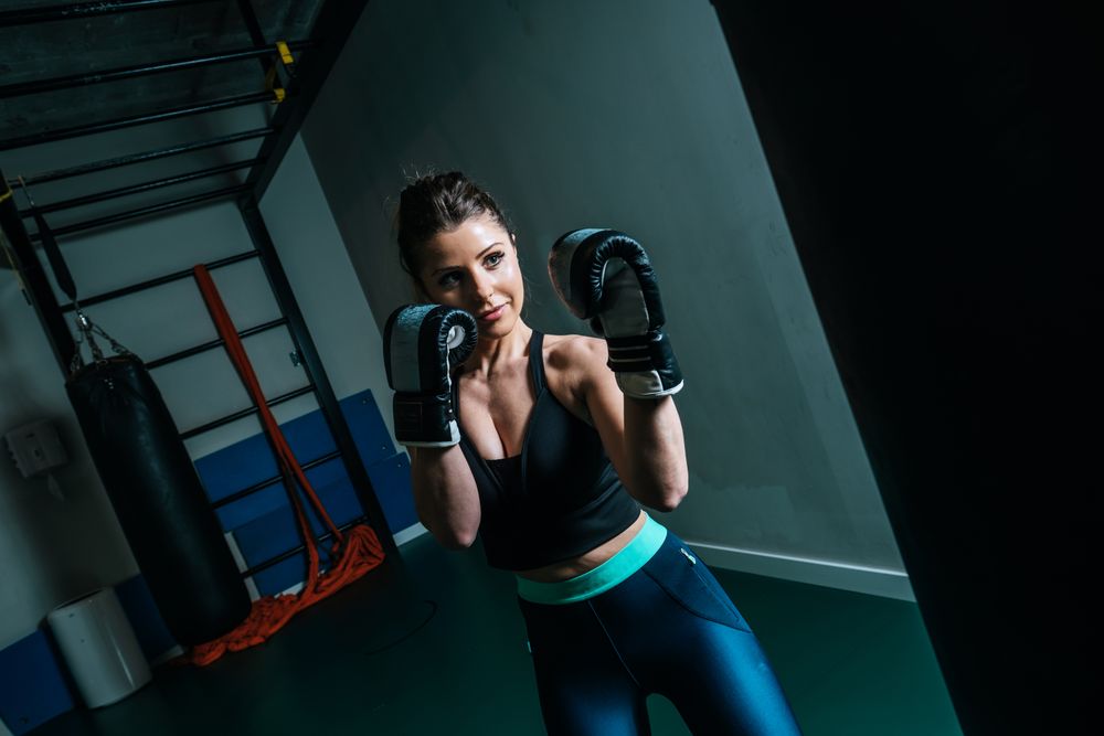 Woman training in gym with punching bag