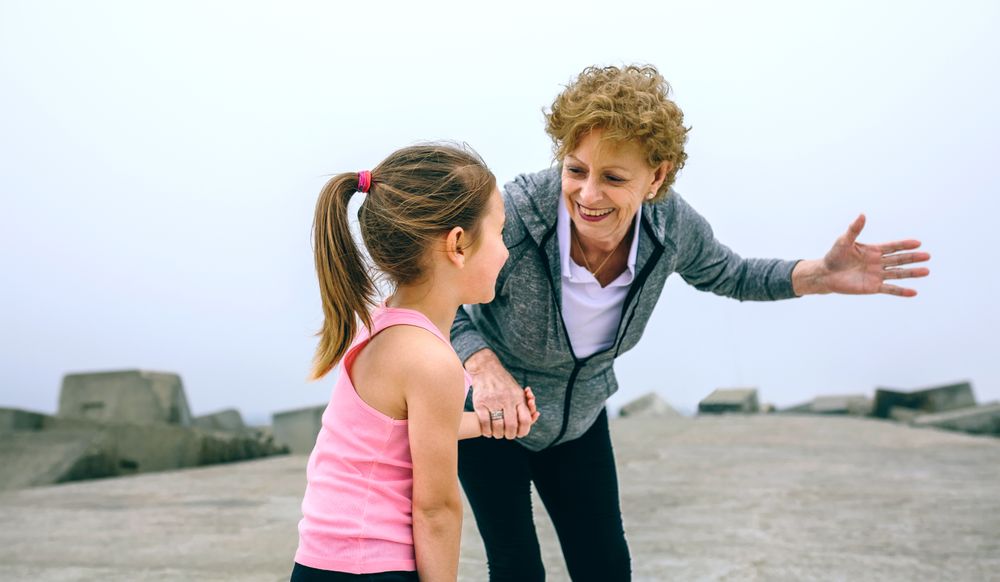 Mature sportswoman talking to little girl