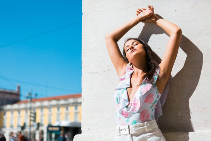 Dreamy stylish woman standing on city street