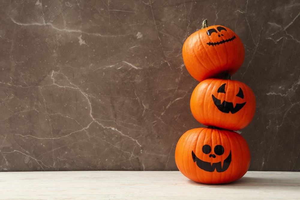 Funny halloween pumpkins against gray background, space for text