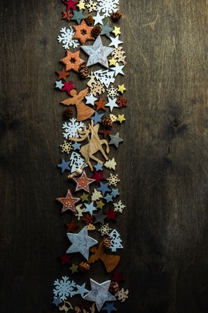 Top view of flat cut out Christmas ornaments in center of wooden table