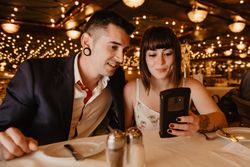 Couple using smartphone in luxury restaurant