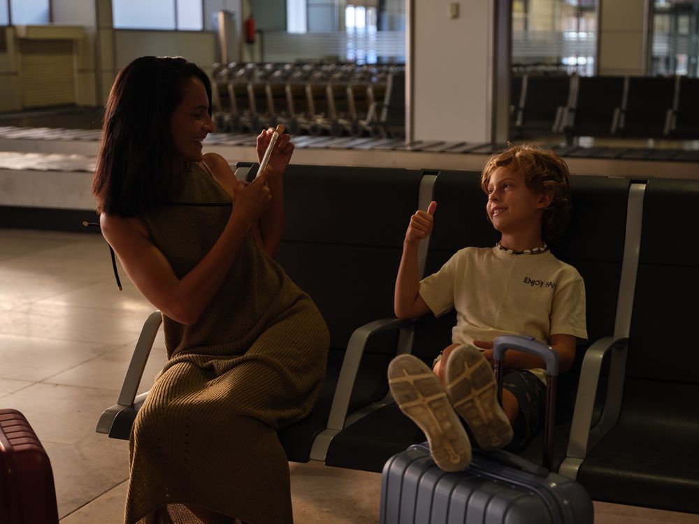 Mother and son taking photos in airport
