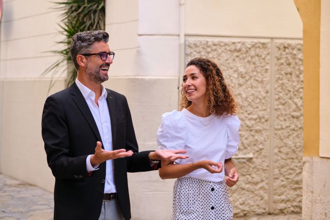 Cheerful colleagues talking on street