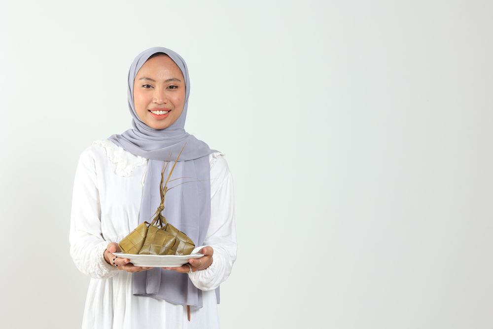 Indonesian Female Holding Plate with Rice Cake with Diamond Shape for Muslim Festive