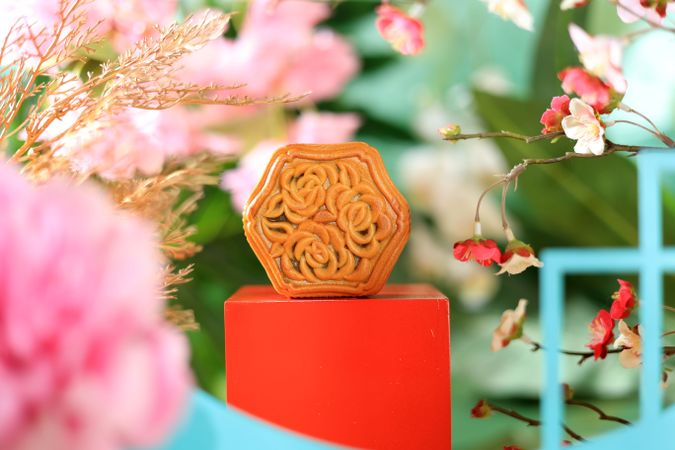 Chinese mooncake with filling surrounded by vibrant flowers