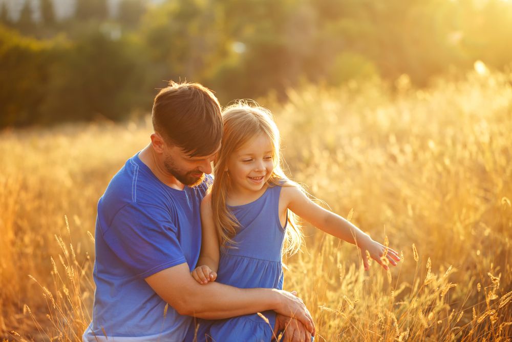 Dad and daughter in field of long grass