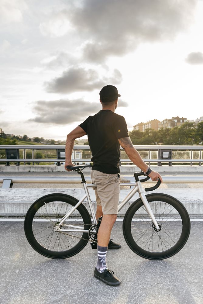 Man with bicycle standing on footbridge