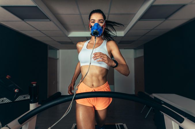 Woman with mask running on treadmill for VO2 max test