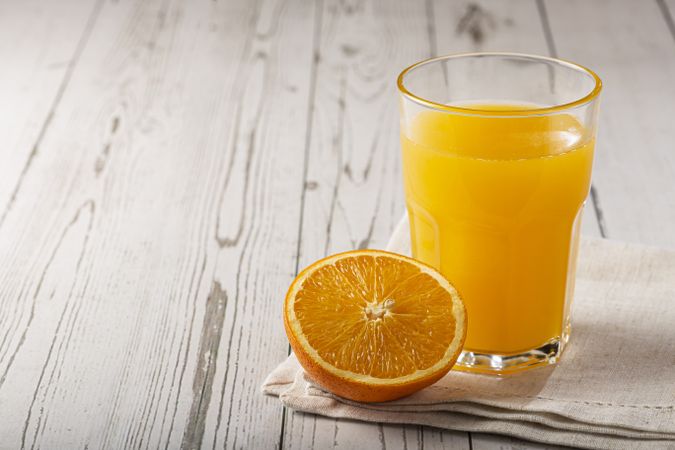 Glass with orange juice on the table.