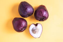 Four Syzygium malaccense or known as jambu jamaika fruits are on a yellow background