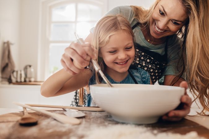 Mother and daughter baking together in kitchen