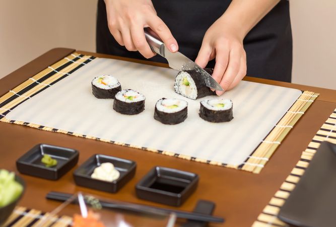 Chef cutting fresh sushi rolls