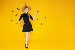 Concept of Halloween, young woman on yellow background