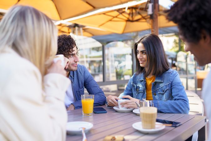 Man and woman looking at each other over an outside table with friends