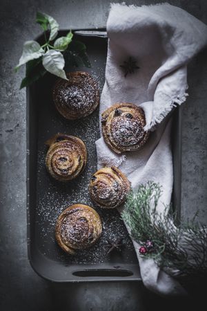 Herbs and napkin near cinnamon rolls