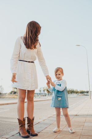 Mother and daughter standing on street