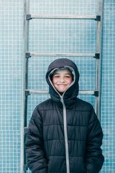 Boy in warm clothes standing in empty pool