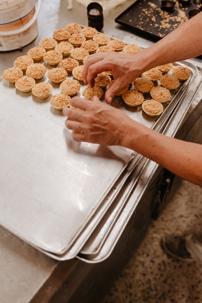 Crop baker arranging patisserie on tray
