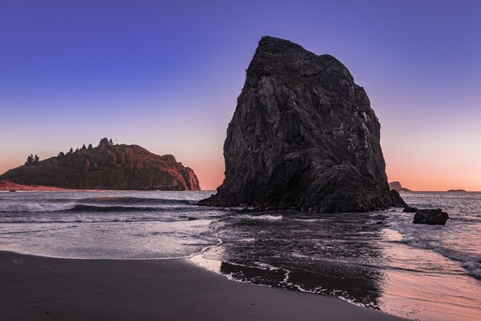 Rocks on the coast at dusk with beautiful purple orange sky