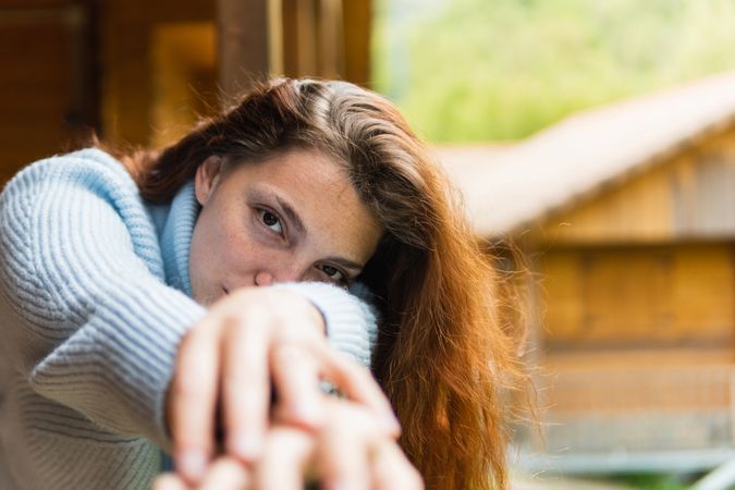 Serene woman relaxing on terrace of house in countryside