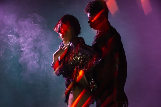 Sensual young dancers near smoke