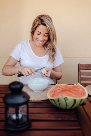 Pregnant woman cutting banana to bowl