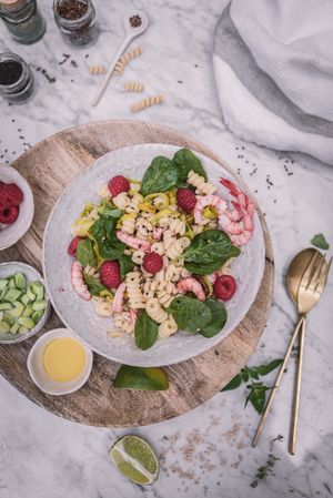 Tasty salad on wooden stand served on decorated table outside