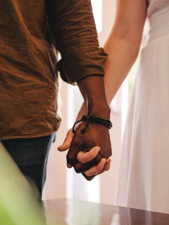 Close up of young man and woman holding hands