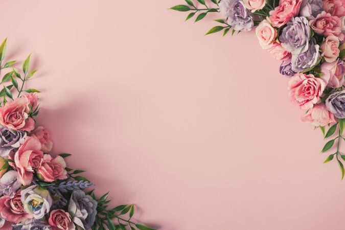 Colorful spring flowers of pink, and purple around the corners on pink background