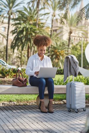 Black female freelancer using on laptop in park