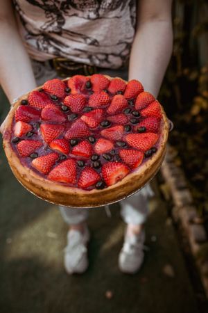 unrecognizable woman holding a delicious strawberry pie