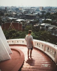 Man on stairs of viewing tower above city