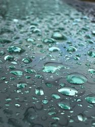 A wet surface with many small drops of water on it