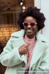 Smiling woman in turquoise jacket wearing sunglasses 4MkKG0