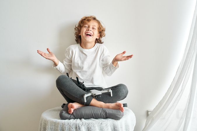 Cheerful preteen boy with drone and remote controller